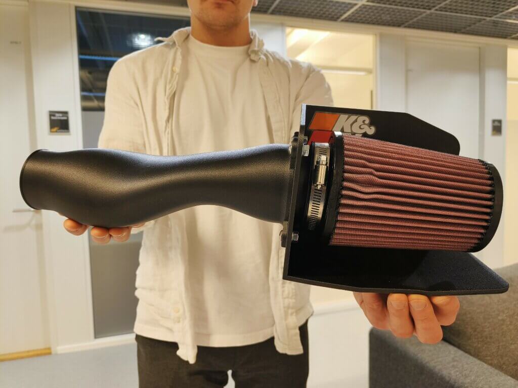 Motorsport Air Intake Assembly part printed with PA6/66CF. Size 600 x 300 x 200mm. Printing time 12hr. Weight 0,8kg.